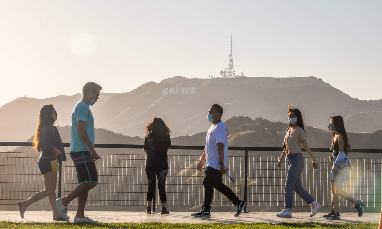 People walk at the Griffith Observatory with a view of the Hollywood sign in Los Angeles.