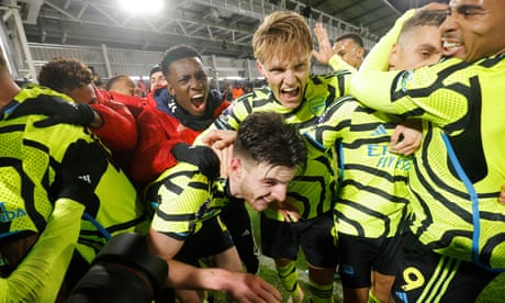 Arsenal's Declan Rice is mobbed by his jubilant teammates after scoring the winner deep in added time