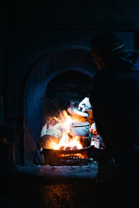 A fire roars in a grate at a bothy. Any luxuries must be carried in, as in the case of this visitor to Glendhu, who brought his own cooking pot when he stopped overnight on his way north to Cape Wrath.
