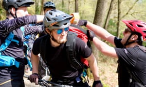 Riders and litter pickers load up a Trash Free Trails rucksack with refuse in Grizedale.