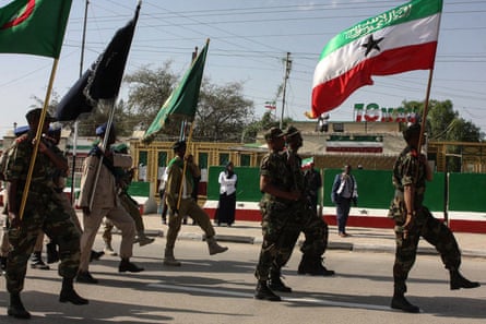 Uniformed soldiers parading with flags behind the flag of Somaliland 