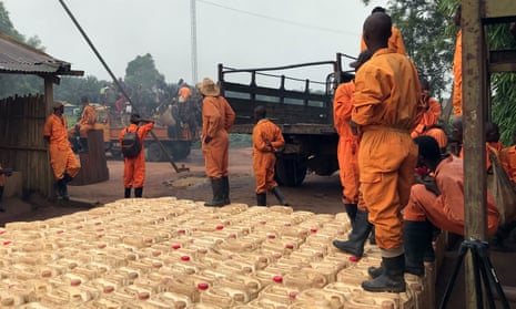 Plantations et Huileries du Congo workers are seen alongside dozens of gallons of pesticide formula in Yaligimba plantation, in the Congolese province of Équateur 