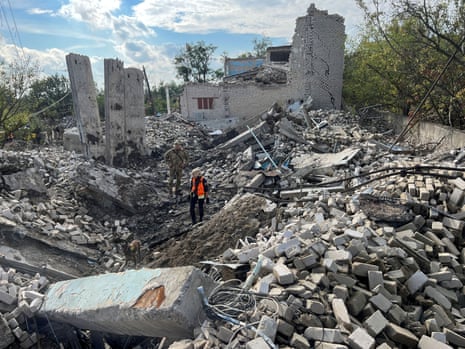 Volunteers search for bodies among remains of a building in the town of Izium in Kharkiv.