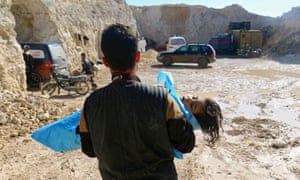 A man carries the body of a child, after what rescue workers described as a suspected gas attack in the town of Khan Sheikhun.