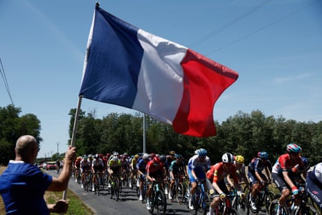 Spectator waves a France flag as the peloton goes by.