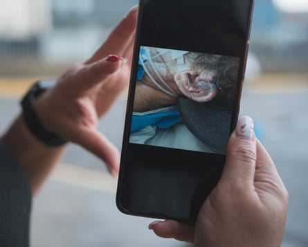 woman holds up cellphone to show photo