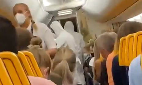 Agents in hazmat suits removing the passenger from the Ryanair flight.