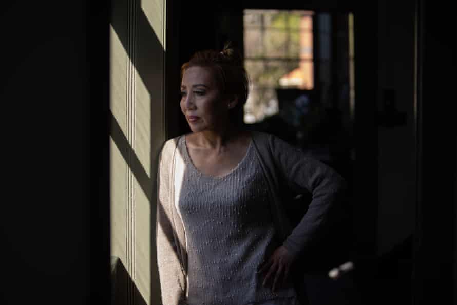 woman stands in shadow with sunlight shining through a window