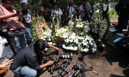 Flowers and cameras on ground at Rubén Espinosa’s funeral.