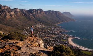 A tourist enjoys the view from the top of Lion’s Head above Cape Town