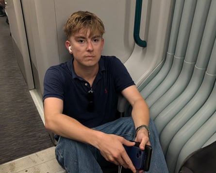 Daniel Garill sitting on the floor in the space between two carriages
