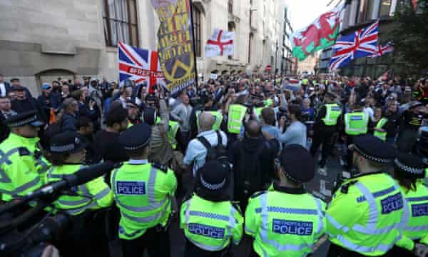 Supporters of Tommy Robinson wave flags as they demonstrate outside the Old Bailey.