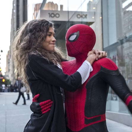 Zendaya clasps her hands around Spider-Man’s neck while he holds her