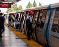 Commuters board a BART train at Fremont station as doors show red warning lights