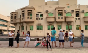 Migrant workers queue for sacks of rice