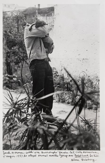 A black-and-white photo of a man holding a cat