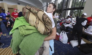 Volunteer Judy Segar carries donated blankets for victims of the flooding, at Lakewood.
