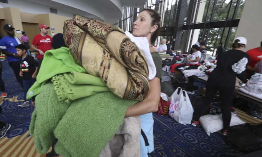 Volunteer Judy Segar carries donated blankets for victims of the flooding, at Lakewood.