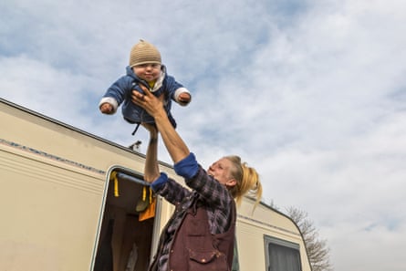 Alice plays with baby Martin outside the caravan.