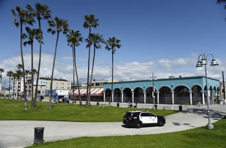 An LAPD patrol car drives through Venice Beach Boardwalk