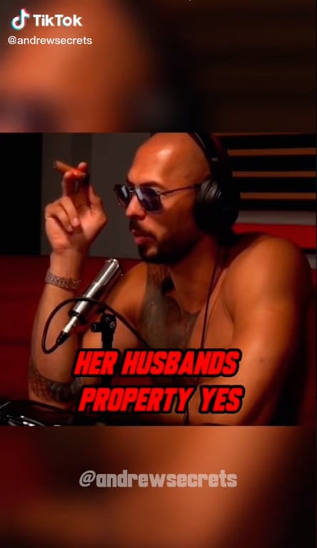 TikTok still of bare-chested Andrew Tate, with headphones and sunglasses, holding a cigar and in front of a mic, with the caption “Her husbands property yes”