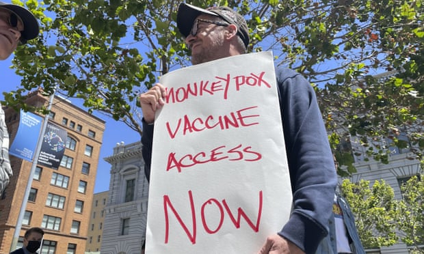 A man holds a sign urging increased access to the monkeypox vaccine during a protest in San Francisco.