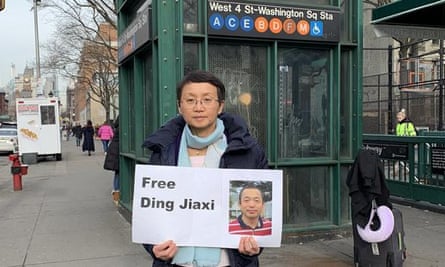 Luo Shengchun with a sign in New York calling for her husband, Ding Jiaxi’s release