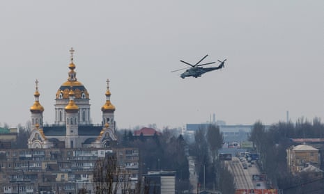 A Russian military helicopter flies near a church in occupied Donetsk.