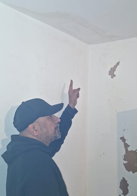 Sanjay Ramburn pointing at a discoloured area of ceiling in his flat.
