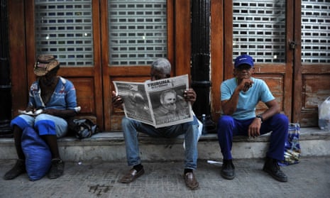 A man reads a newspaper in a street of Havana.