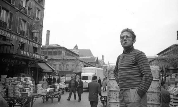 A man standing in the street in the food market of Les Halles