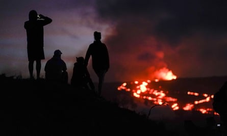 Les gens regardent la lave couler du plus grand volcan actif du monde.