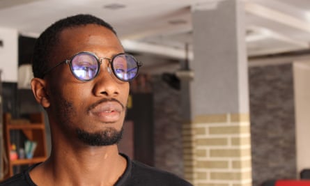 A solemn young African man looks into the distance