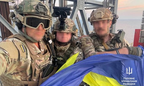 Ukrainian soldiers holding a flag of Ukraine on an oil platform in the Black Sea