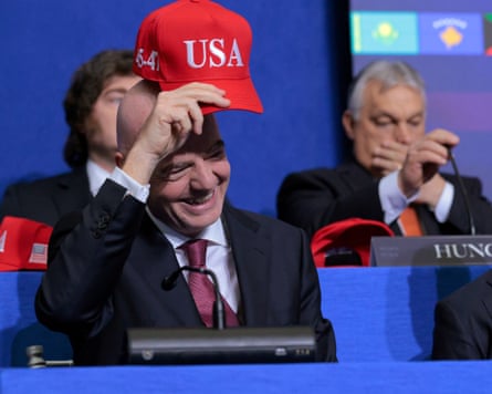 Fifa president Gianni Infantino holds up a red hat branded ‘USA’ at the inaugural Board of Peace meeting