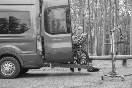 A man in a wheelchair ramps up into the back of a van