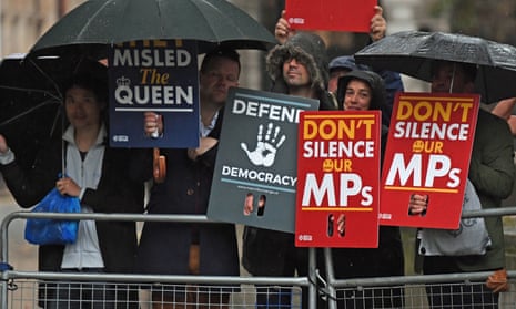 Protesters shelter from the rain outside the supreme court in London