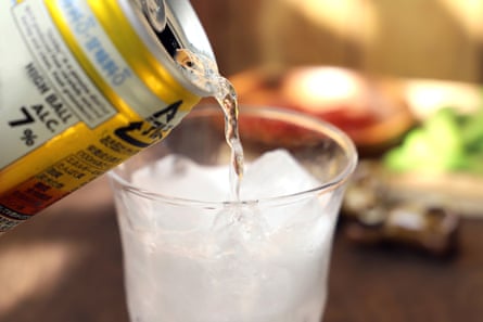 Cold chilled whisky soda poured from a can into a cup with ice