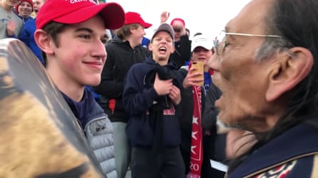 Covington Catholic high school students stand in front of Nathan Phillips in Washington.