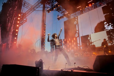 Sombr on stage, one arm in the air