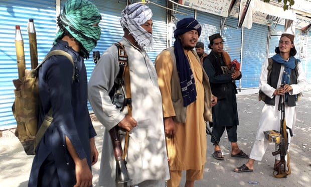 Taliban fighters stand guard in Kunduz after capturing the strategic city in northern Afghanistan on Sunday