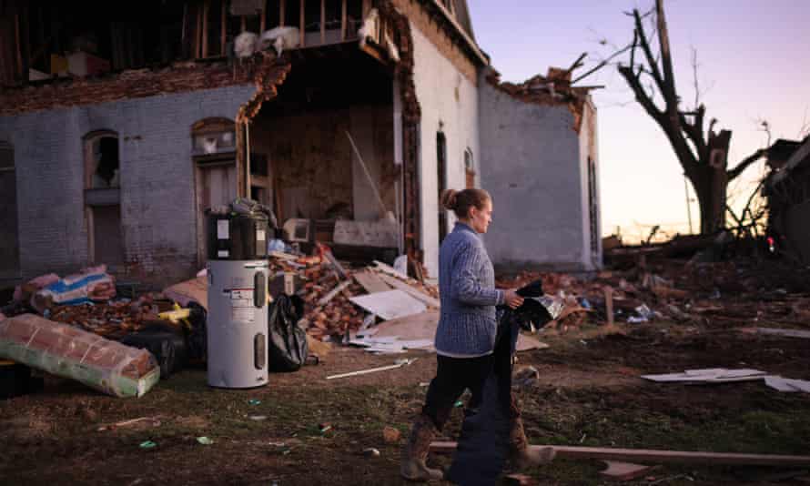 A woman salvages items from a home that was destroyed after being hit by a tornado late Friday in Mayfield, Kentucky