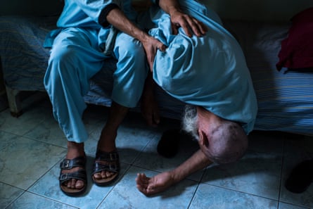 An elderly man falls from his bunk at the Helmand Drug Addict’s Treatment Center in the provincial capital, Lashkar Gah.