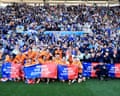 Cardiff City players and staff celebrate in front of their supporters after securing promotion to the Championship