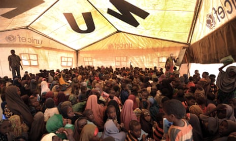 Lots of children sitting under Unicef tent