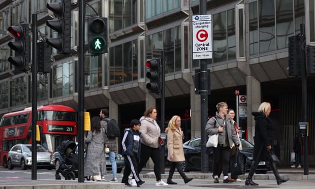 Pessoas andam em uma rua de Londres perto de um ônibus de dois andares