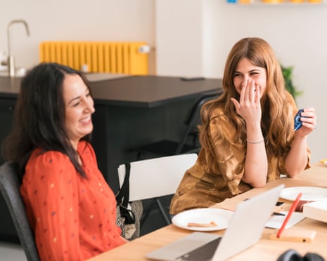 Two women share a joke in an office
