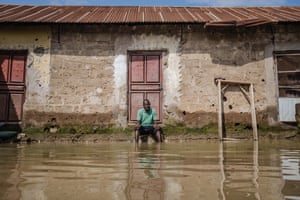 Idris al-Hassan sits in front of his neighbour’s house, with his legs in the floodwater.
