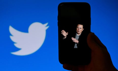 a phone screen displays a photo of Elon Musk with the Twitter logo shown in the background