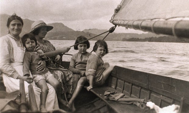 Mavis Guzelian (née Altounyan), the inspiration for the character Titty in Arthur Ransome’s Swallows and Amazons, on the lap of a nanny while boating with her sisters Taqui (left) and Susie on Coniston Lake in the early 1920s.